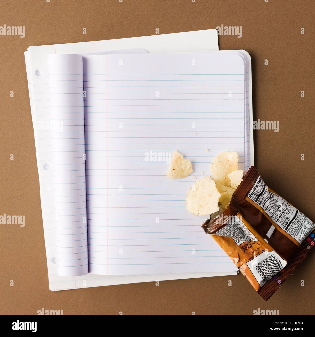 Notebook mit einem Beutel der Späne verschüttet auf eine leere Seite Stockfoto