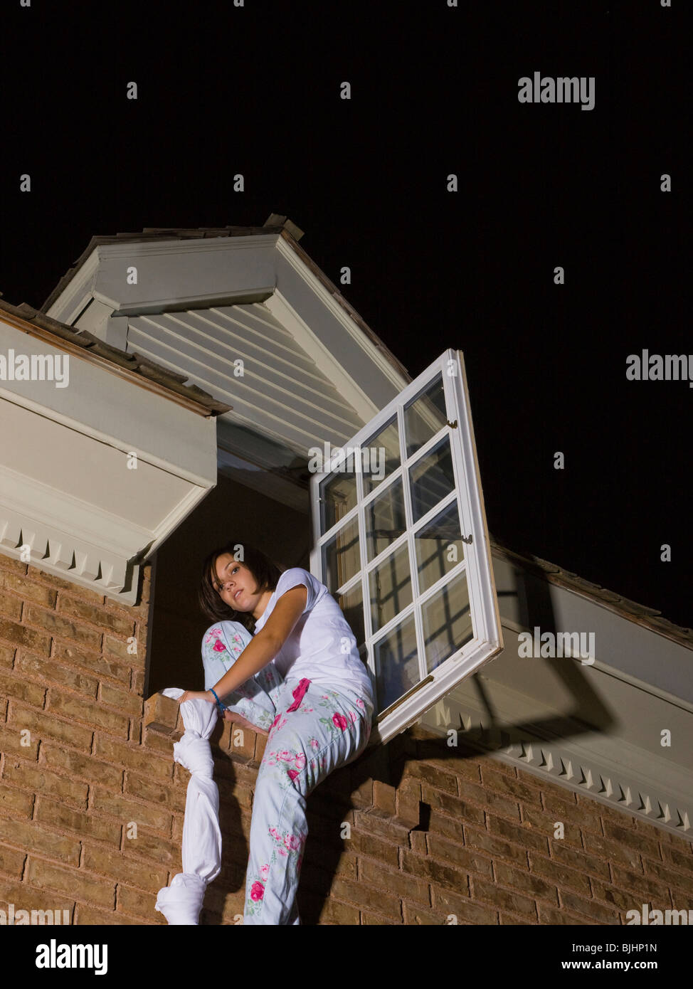 Teenager aus ihrem Schlafzimmerfenster Klettern Stockfoto