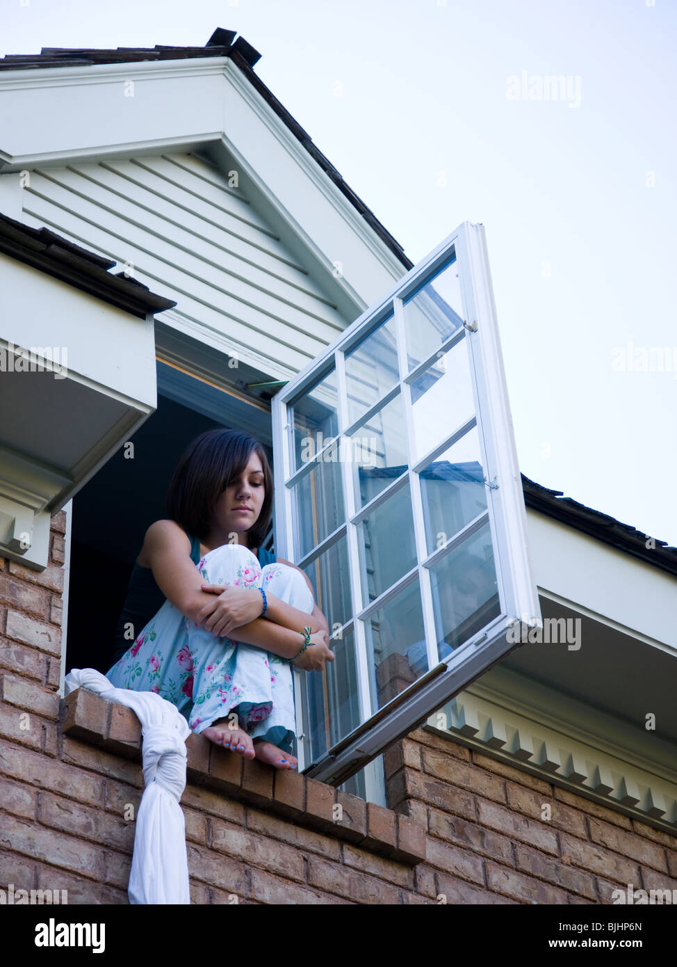 Teenager aus ihrem Schlafzimmerfenster Klettern Stockfoto