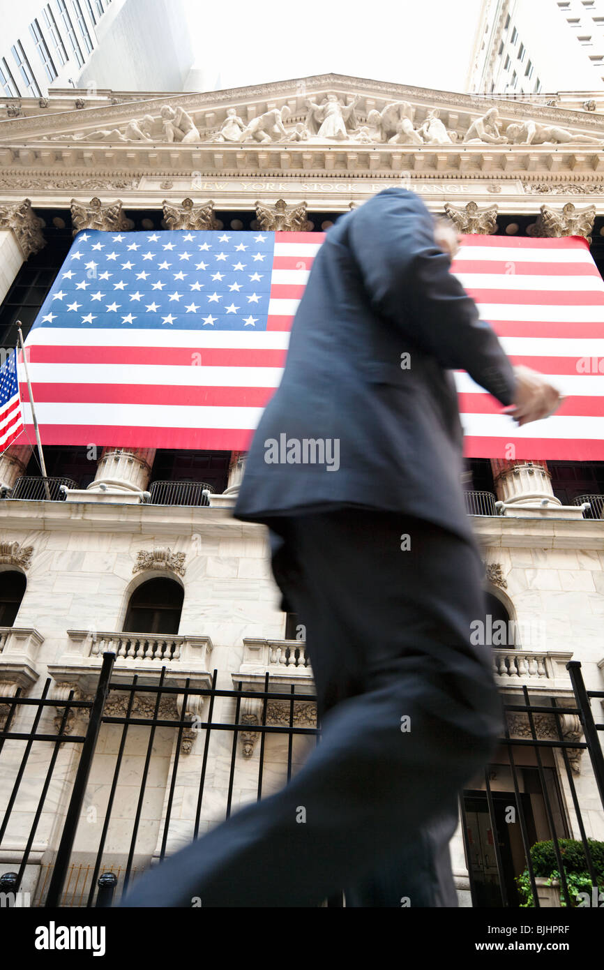 New York Stock Exchange mit Business-Mann vorbeigehen Lesen von Text in Motion blur, Wall Street, Manhattan, New York, USA Stockfoto