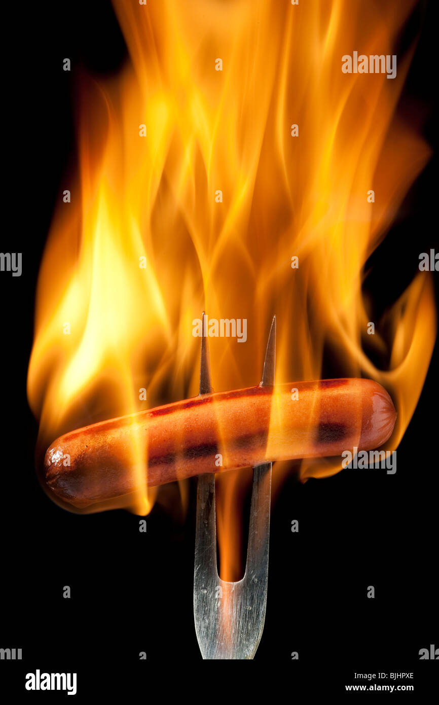 Hot Dog auf einer Gabel vollständig in Flammen verschlungen Stockfoto