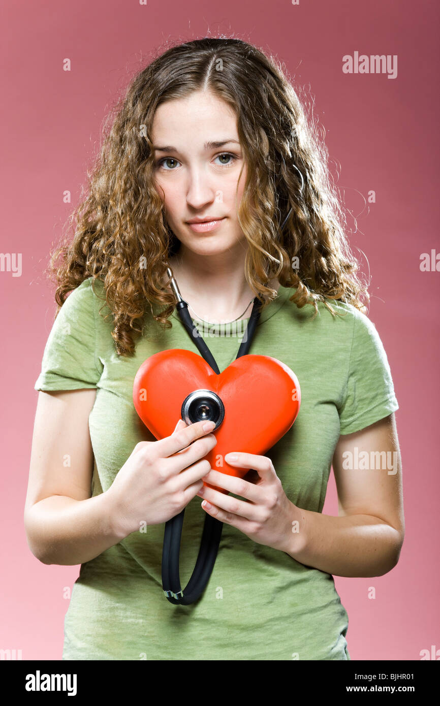 Frau mit einem Stethoskop bis zu ihrem Herzen Stockfoto