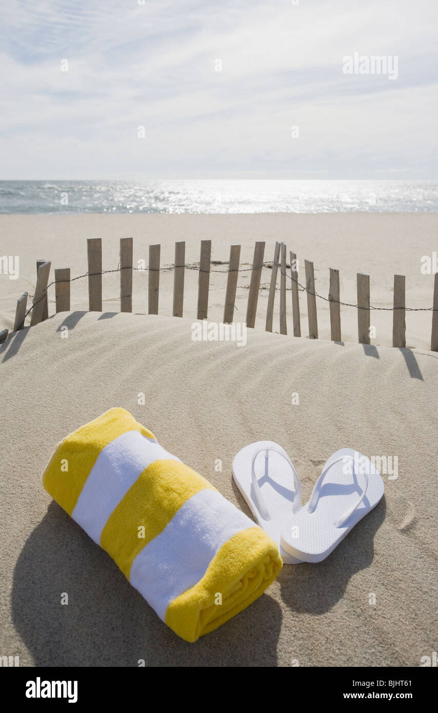 Handtuch und Flip Flops am Strand Stockfoto