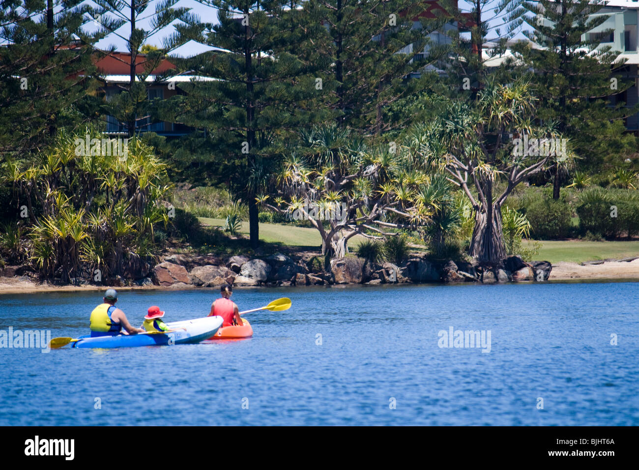 Familie Kajak auf Lagune bei Sonnenschein-Küste Stockfoto