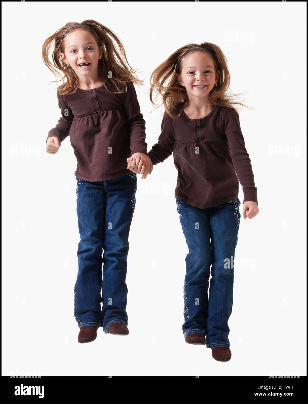 Eineiige Zwillinge springen Stockfoto