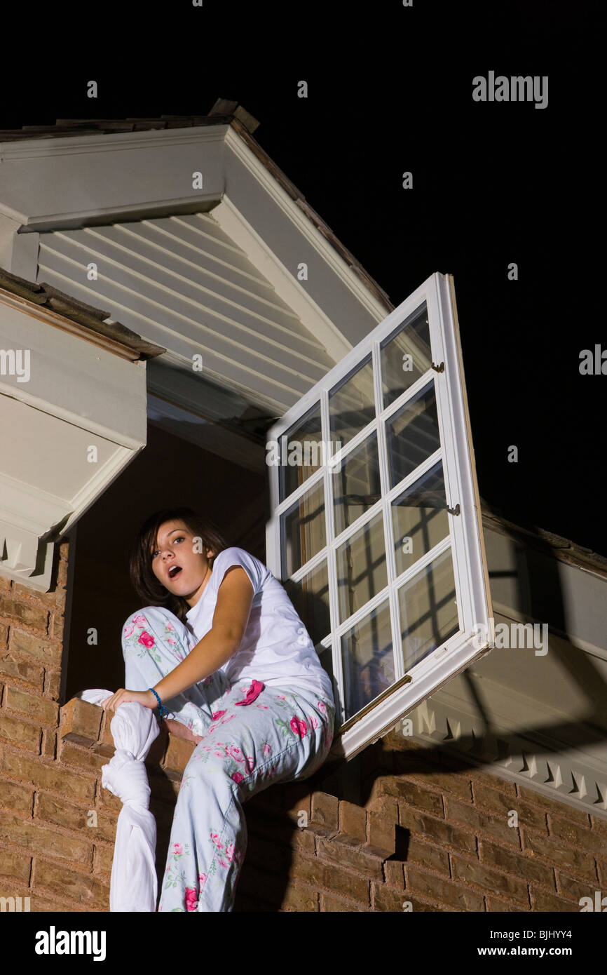 Teenager aus ihrem Schlafzimmerfenster Klettern Stockfoto