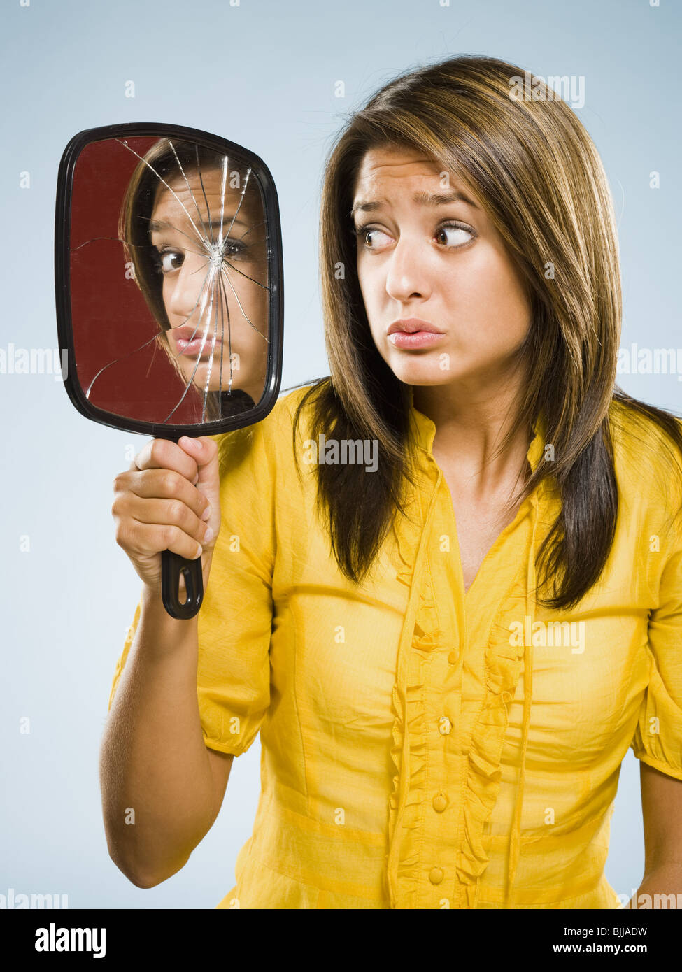 Frau auf der Suche in zerbrochene Spiegel nervös Stockfoto