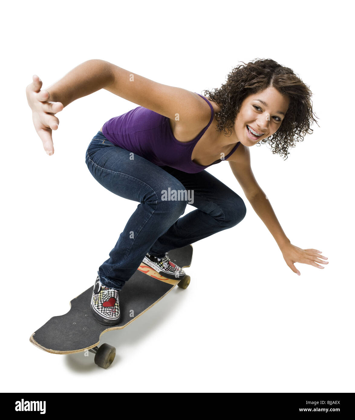 Mädchen mit Zahnspange auf Skateboard lächelnd Stockfoto