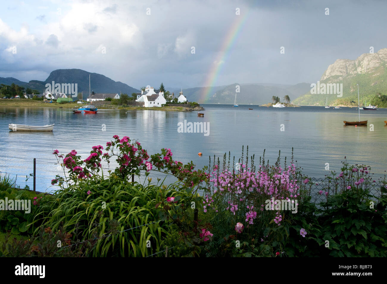 Blick über Plockton Bay mit Regenbogen und Blumengarten Stockfoto