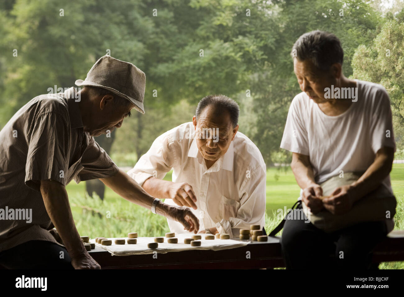 Drei Männer im freien lächelnd Brettspiel Stockfoto