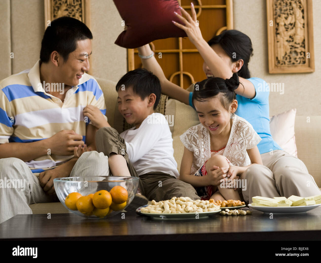 Familie mit Kissen auf Sofa Lachen zu bekämpfen Stockfoto