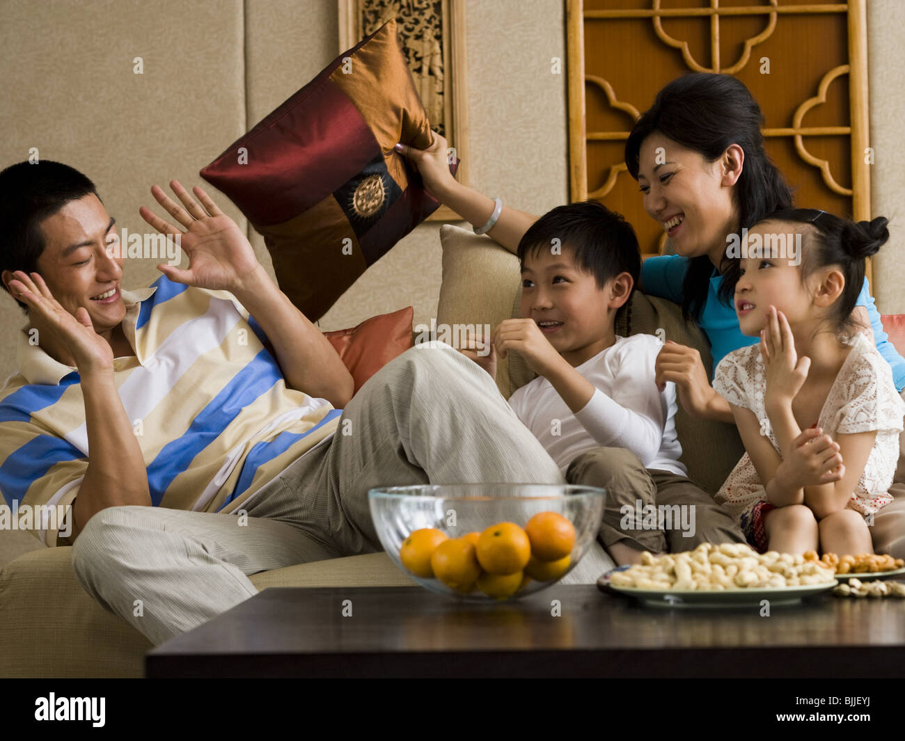 Familie mit Kissen auf Sofa Lachen zu bekämpfen Stockfoto