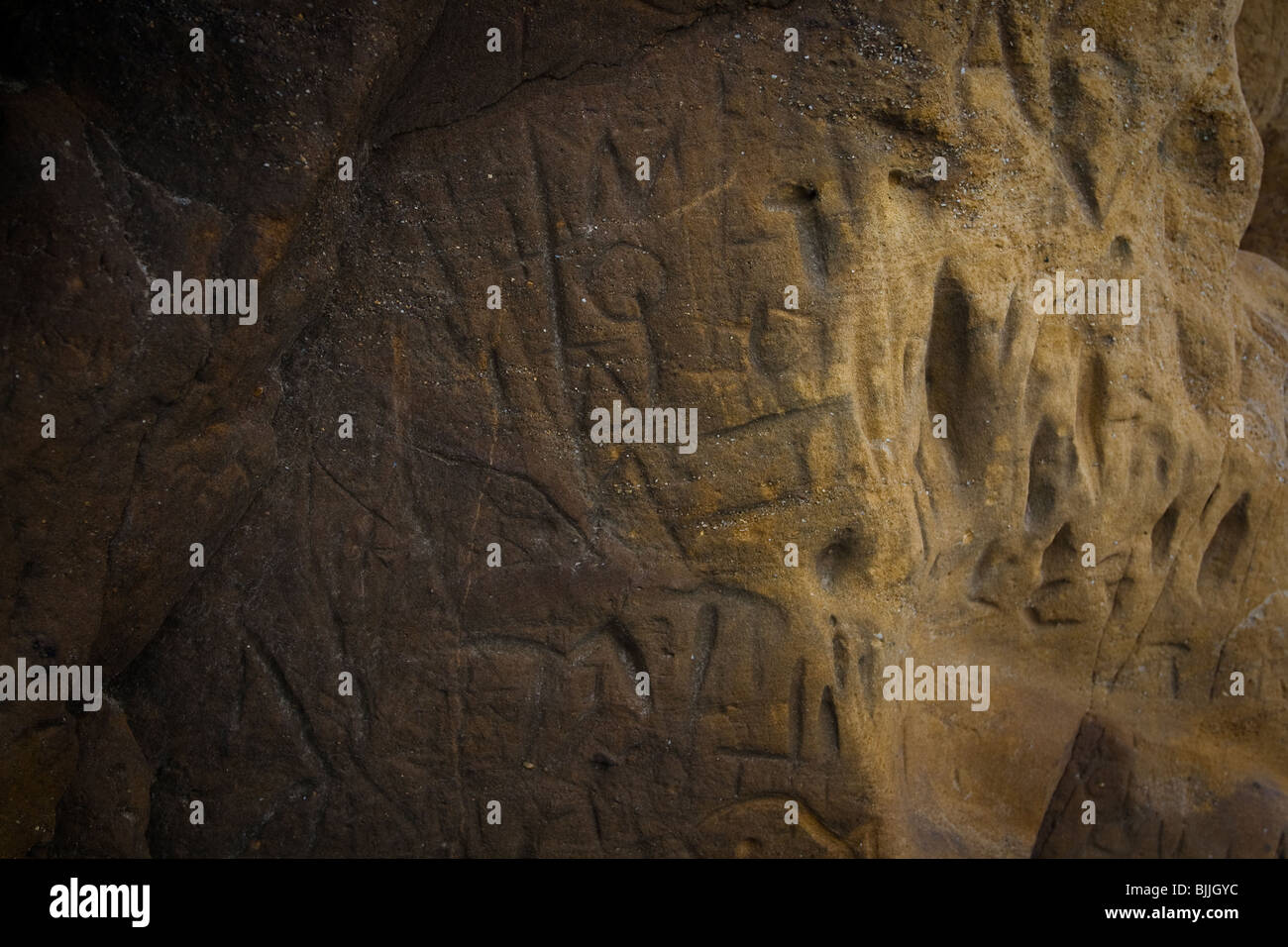 Buchstaben und Symbole in Sandstein gehauen Stockfoto