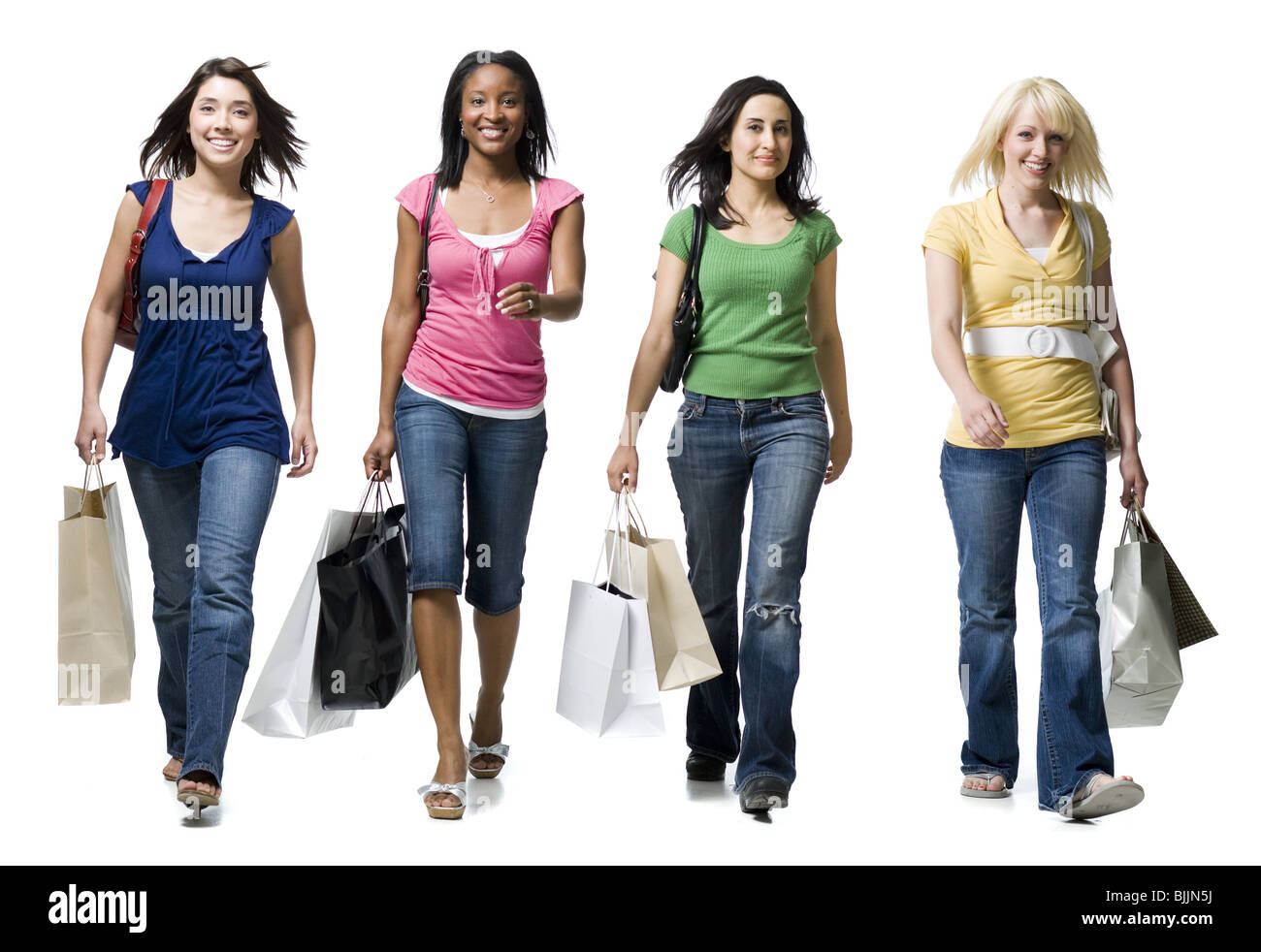 Vier Frauen zu Fuß und lächelnd mit Einkaufstaschen Stockfoto
