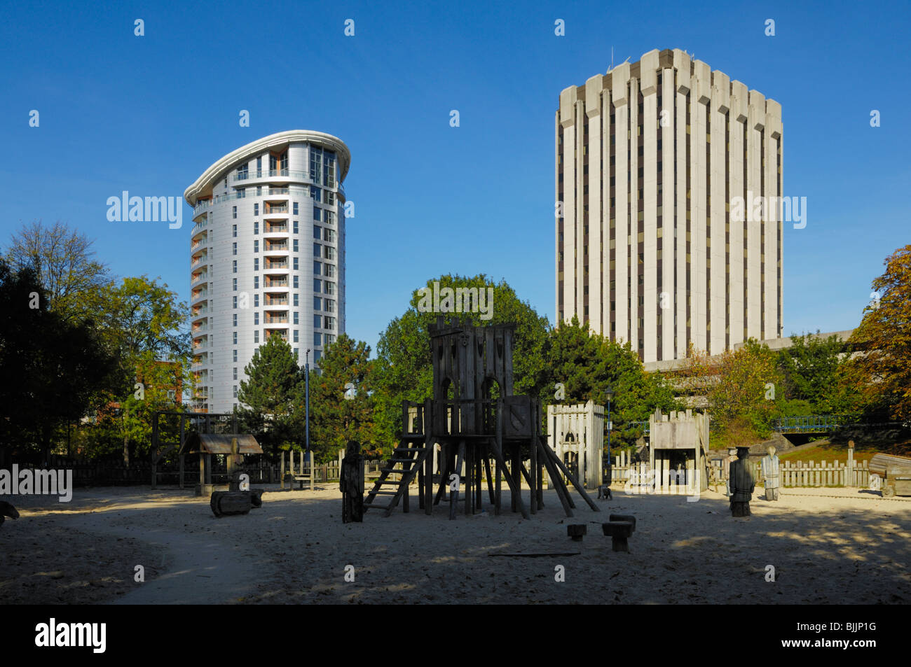 Der Cabot Circus Tower und ein älteres Bürogebäude mit Blick auf den Kinderspielplatz im Castle Park, Bristol, England. Stockfoto