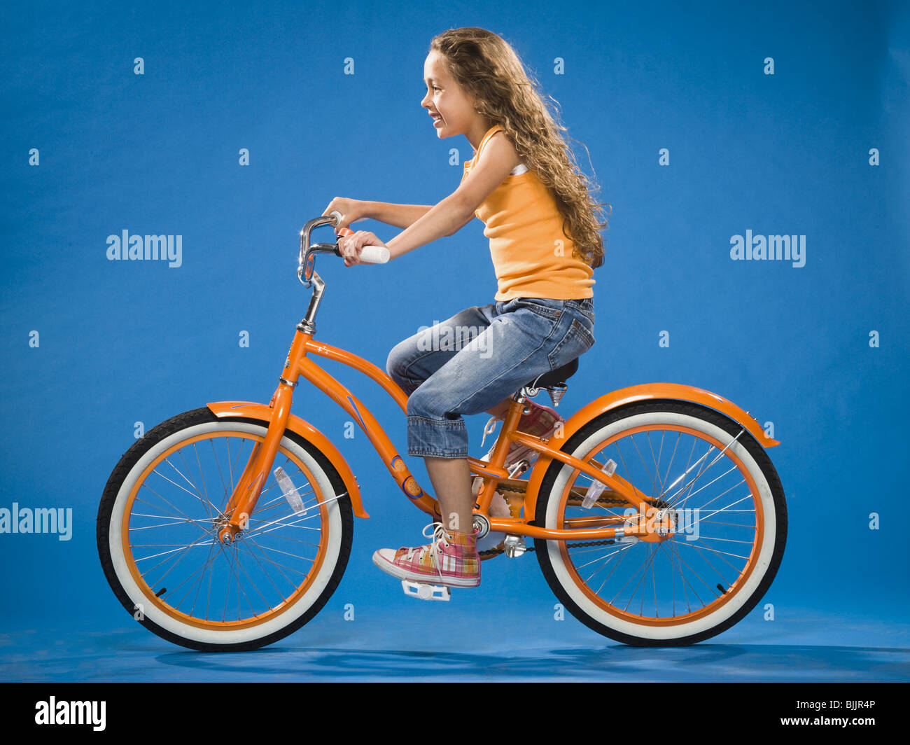 Mädchen reiten orange Fahrrad Profil Stockfoto