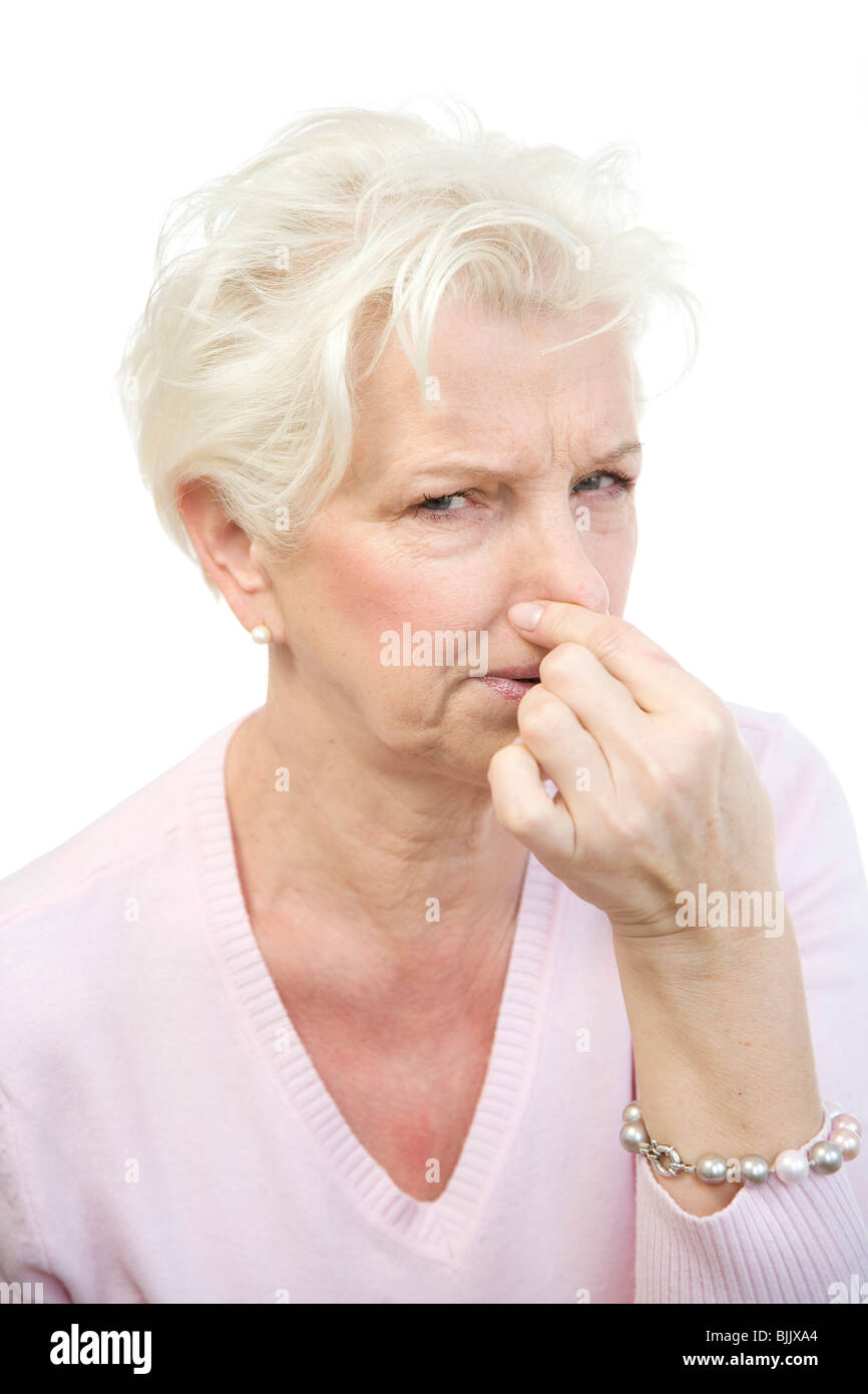 Frau, 60, halten ihre Nase in Ekel Stockfoto