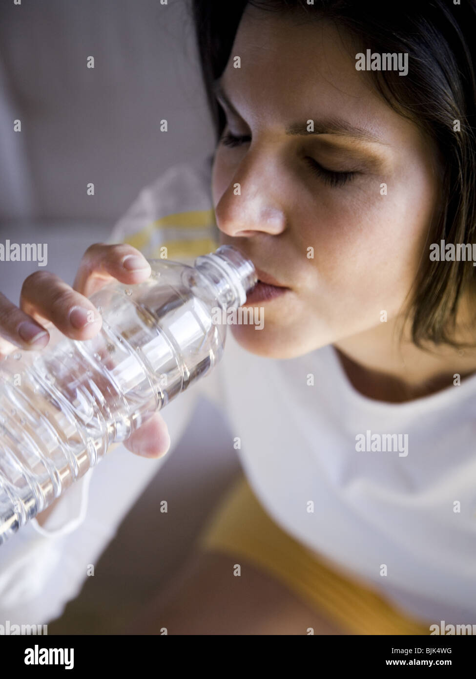 Frau, sitzen und trinken Mineralwasser Stockfoto