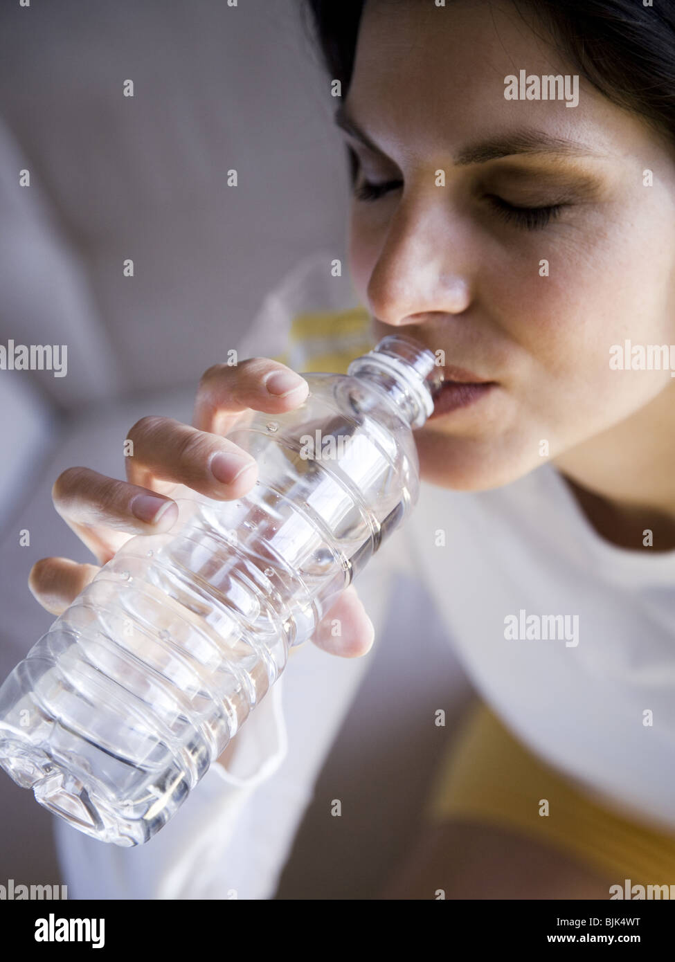 Frau, sitzen und trinken Mineralwasser Stockfoto