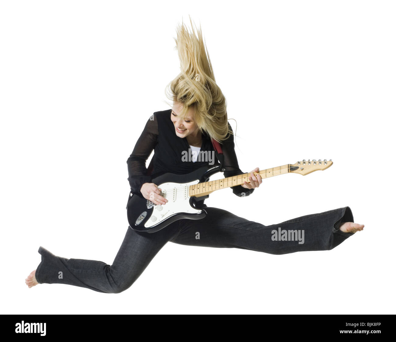 Profil von Frau springt mit e-Gitarre Stockfoto