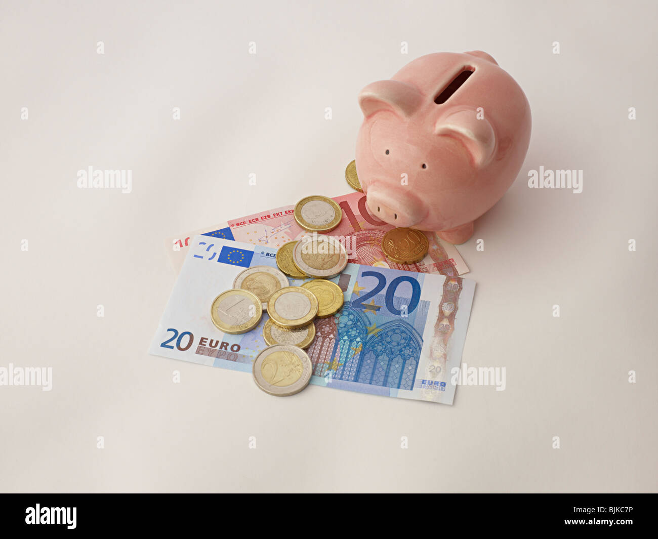 Rosa Sparschwein stand vor der Euro-Währung Stockfoto