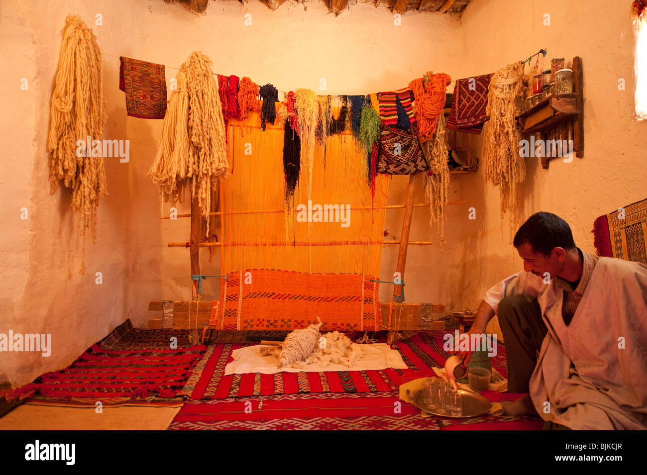 Dies ist am Menschenbild ein Berber marokkanischen Pfefferminztee in seinem Teppichgeschäft in Strömen. Stockfoto