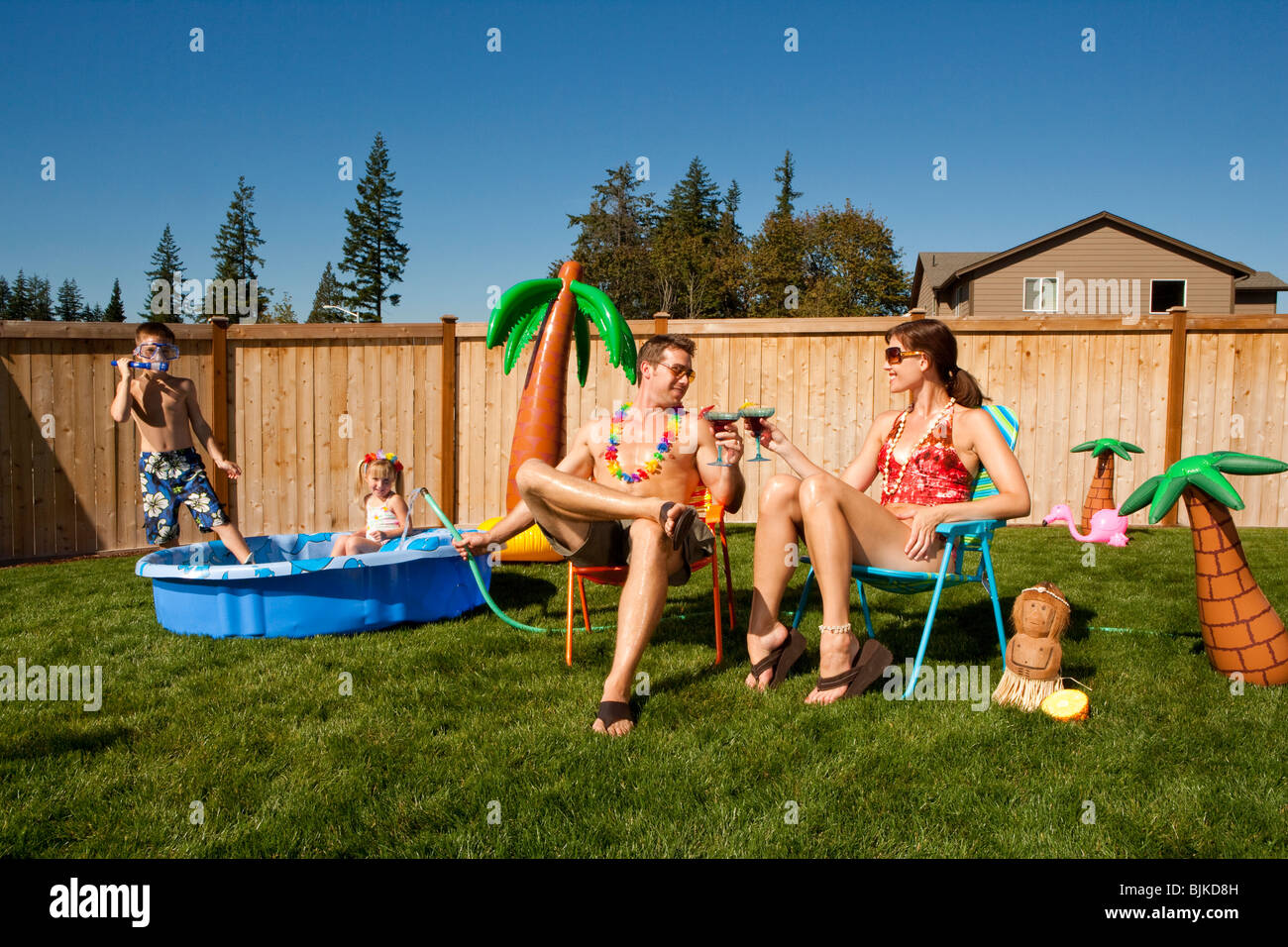 Familie im Hof mit Kinderbecken und cocktails Stockfoto