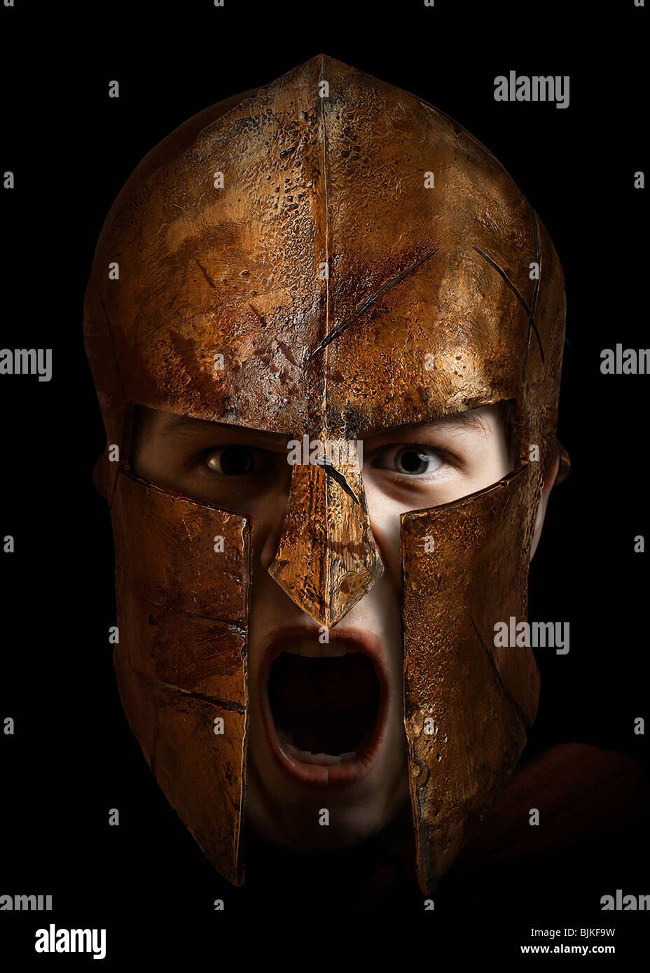 Junge Krieger schreiend mit einem spartanischen Helm Stockfoto