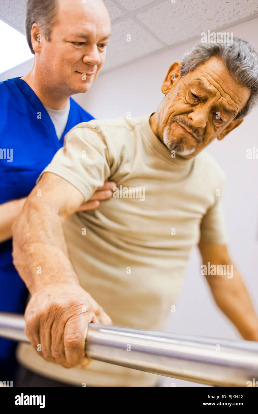 Physiotherapeut, hält ein Patient während des Gehens Stockfoto