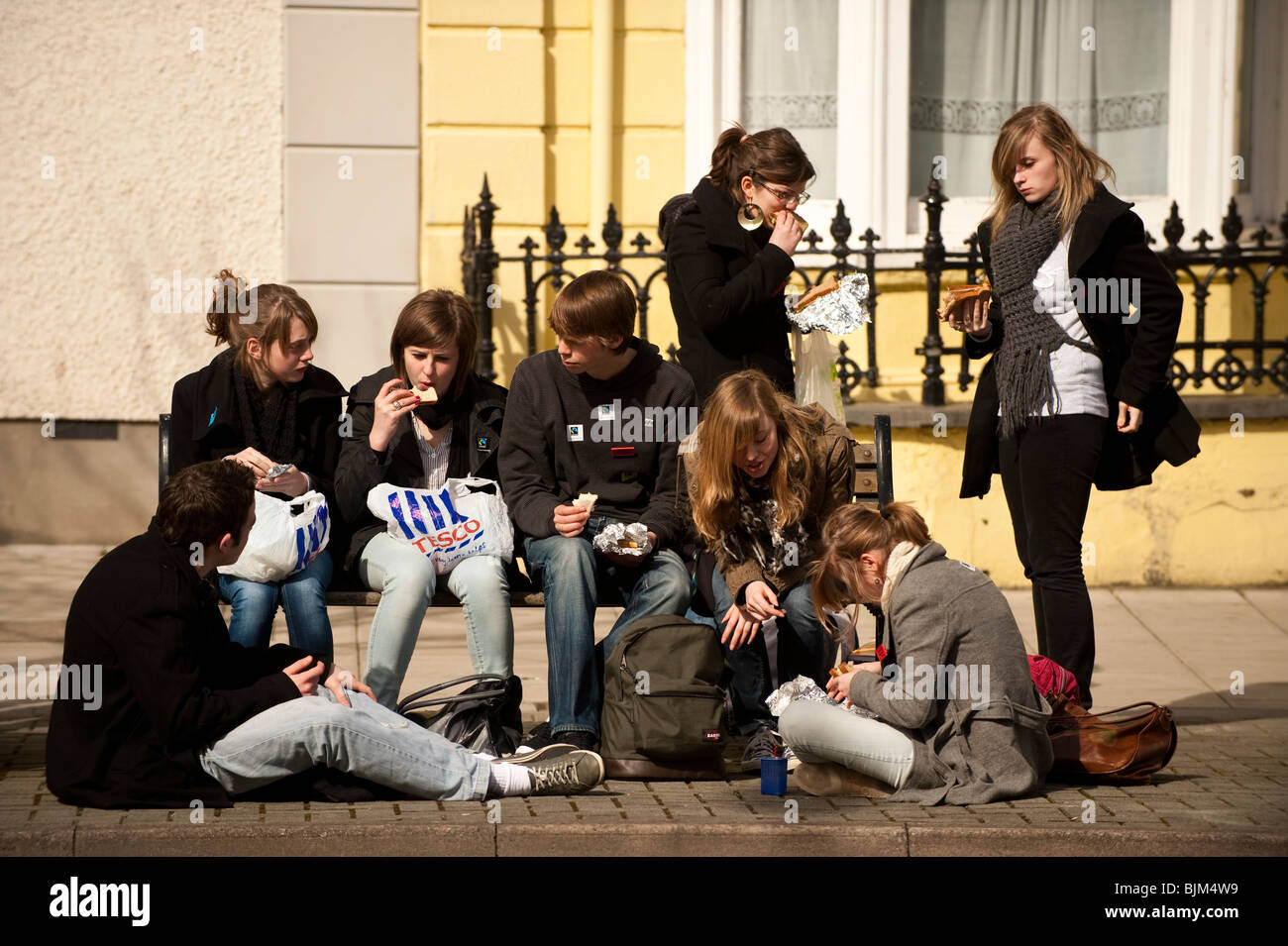 Eine Gruppe von Jugendlichen Essen Lunchpaket im Freien, UK Stockfoto