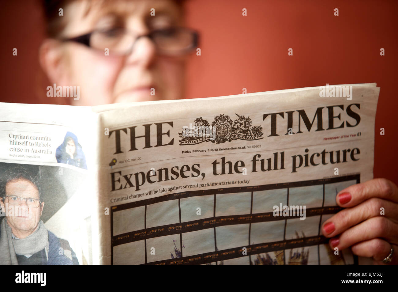 Frau liest eine Kopie von The Times Zeitung mit der Schlagzeile. Aufwendungen, das vollständige Bild. Stockfoto