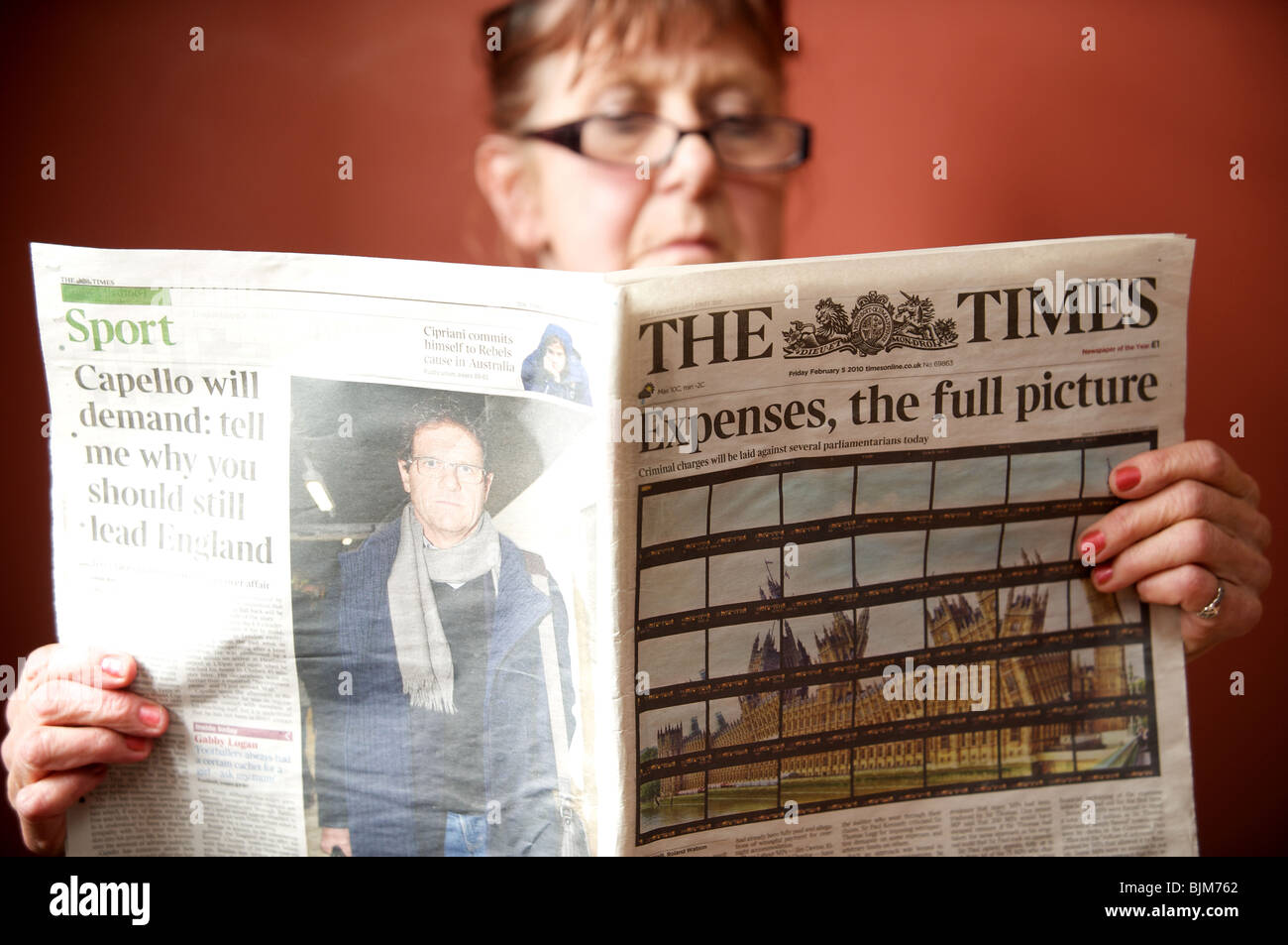 Frau liest eine Kopie von The Times Zeitung mit der Schlagzeile. Aufwendungen, das vollständige Bild. Stockfoto