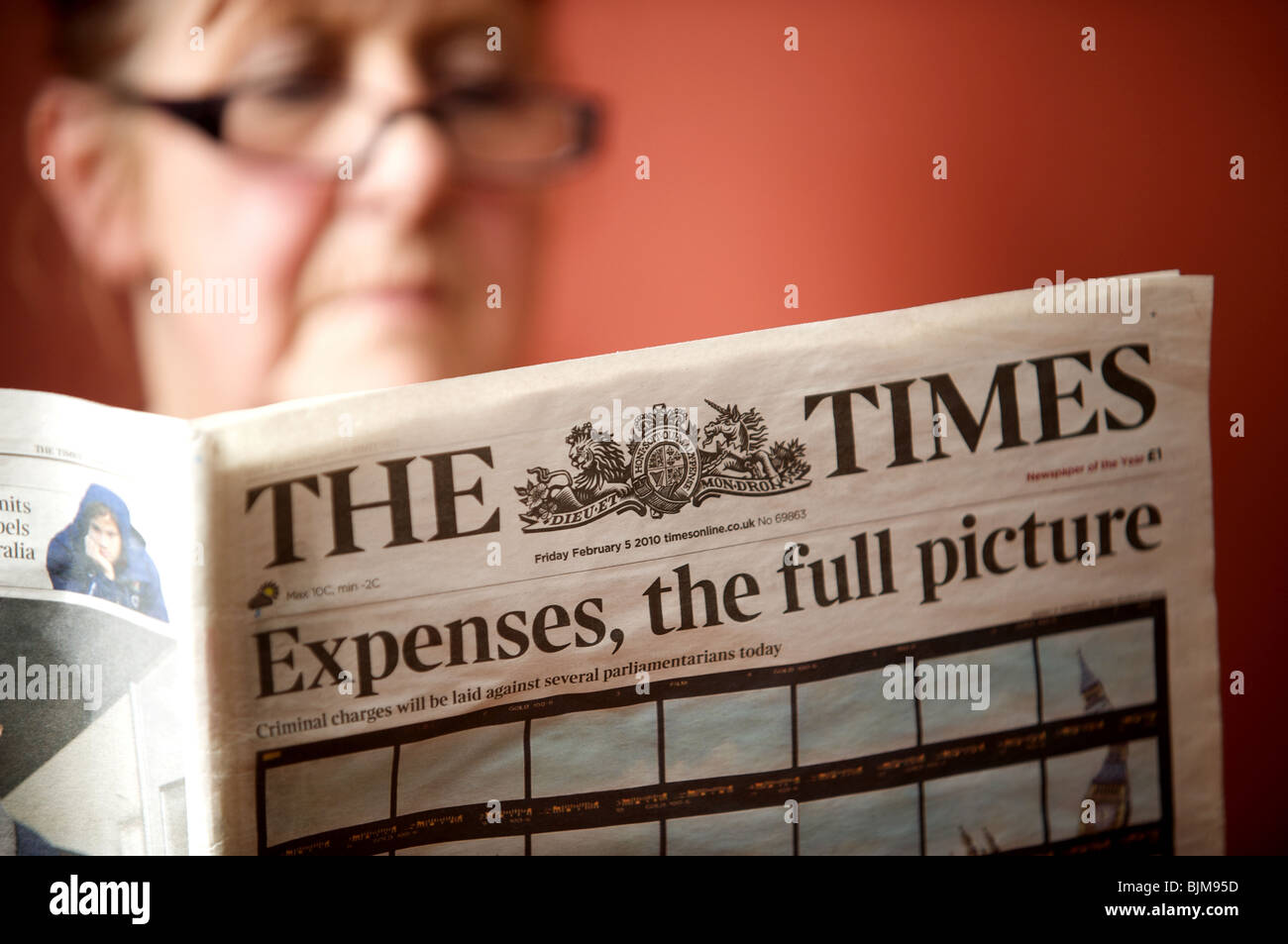 Frau liest eine Kopie von The Times Zeitung mit der Schlagzeile. Aufwendungen, das vollständige Bild. Stockfoto