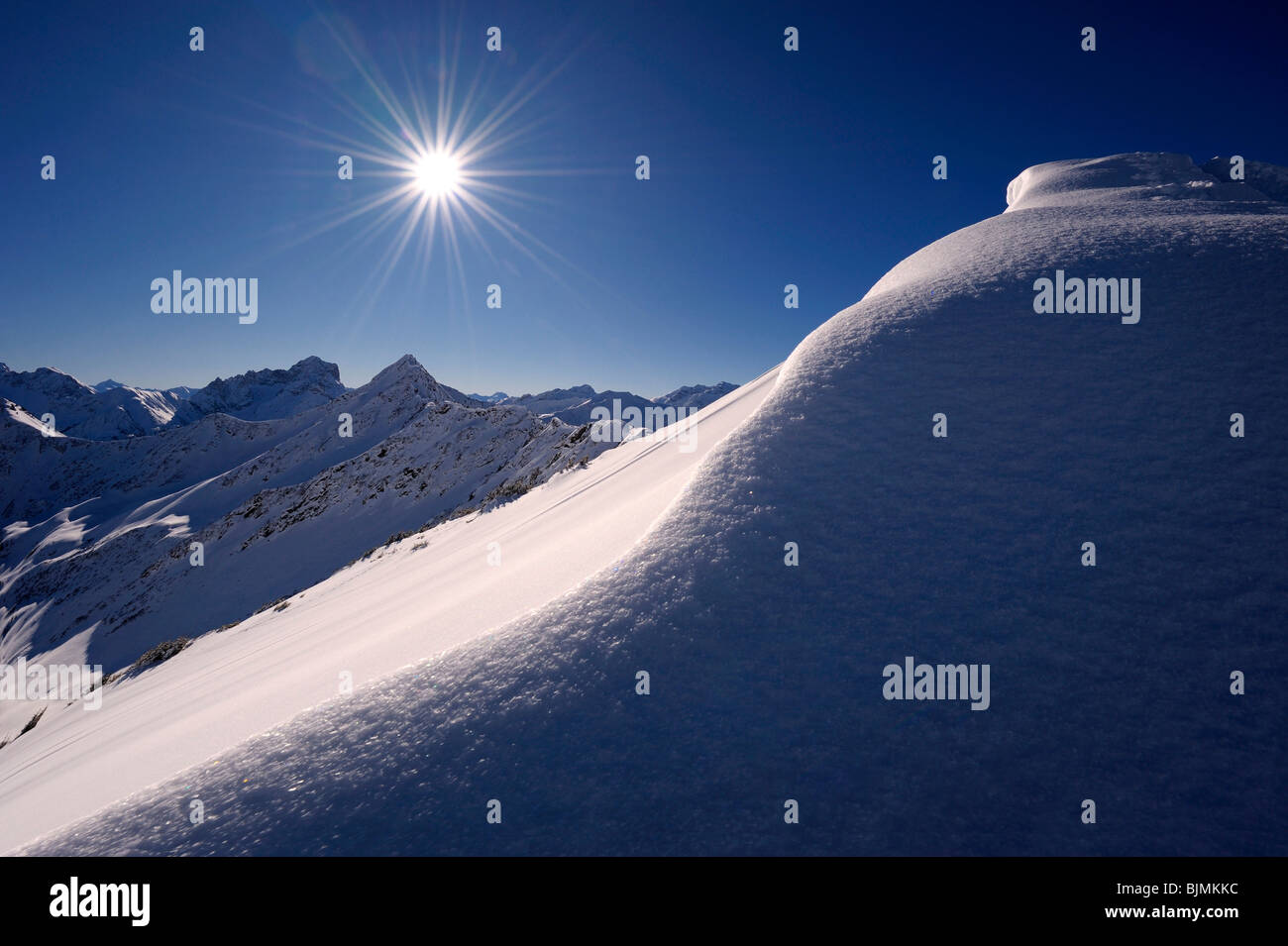 Schnee-Gesims mit einem sternförmigen Sonne vor einem Bergpanorama, Rietzler, Kleinwalsertal, Vorarlberg, Österreich, Europa Stockfoto