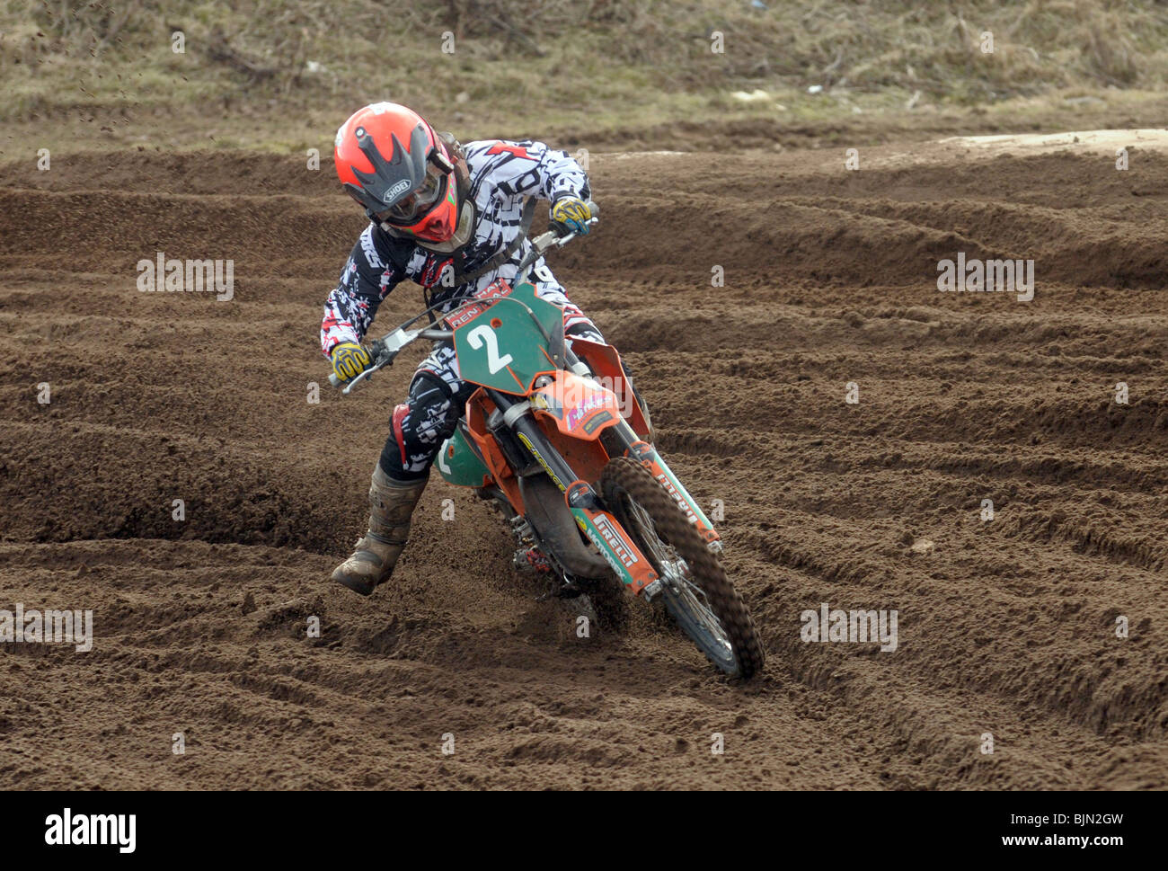 Eine kleiner Junge Rennfahrer nimmt eine Biegung auf seinem Motocross-bike Stockfoto