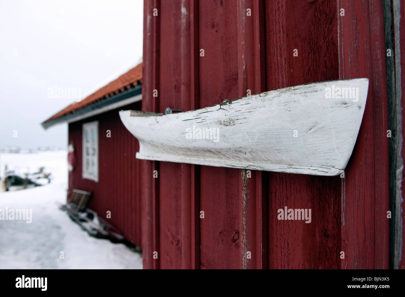 Kleinen alten Holzboot an Wand des roten Bootshaus in Fiskebackskil an Bohuslan Küste in Vastra Gotaland Schweden Stockfoto