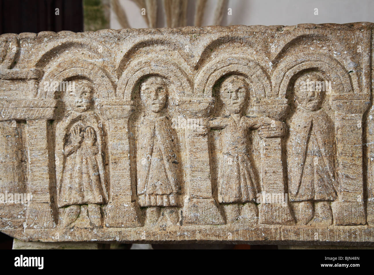 Schnitzen von verschiedenen Figuren auf 12. Jahrhundert Schriftart, Breckles, Norfolk Stockfoto