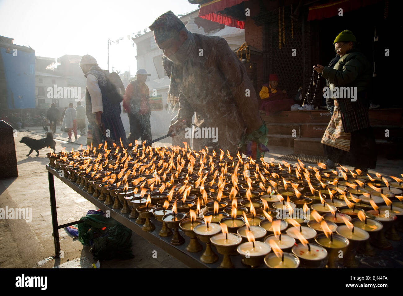 Ein Mann, die Kerzen vor dem Eingang zum Boudhanath Stupa in Kathmandu, Nepal Stockfoto
