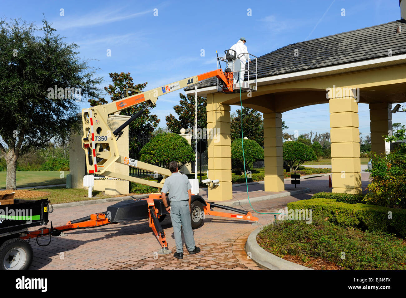Reparaturmannschaft arbeitet auf dem Dach eines Gebäudes Stockfoto