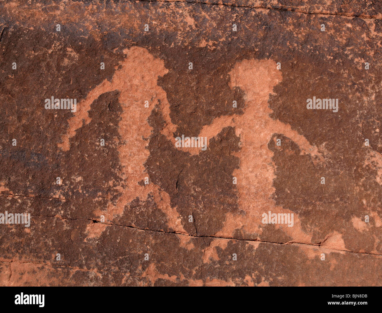 Alte indianische Petroglyphen auf einer Mauer aus rotem Sandstein. Stockfoto