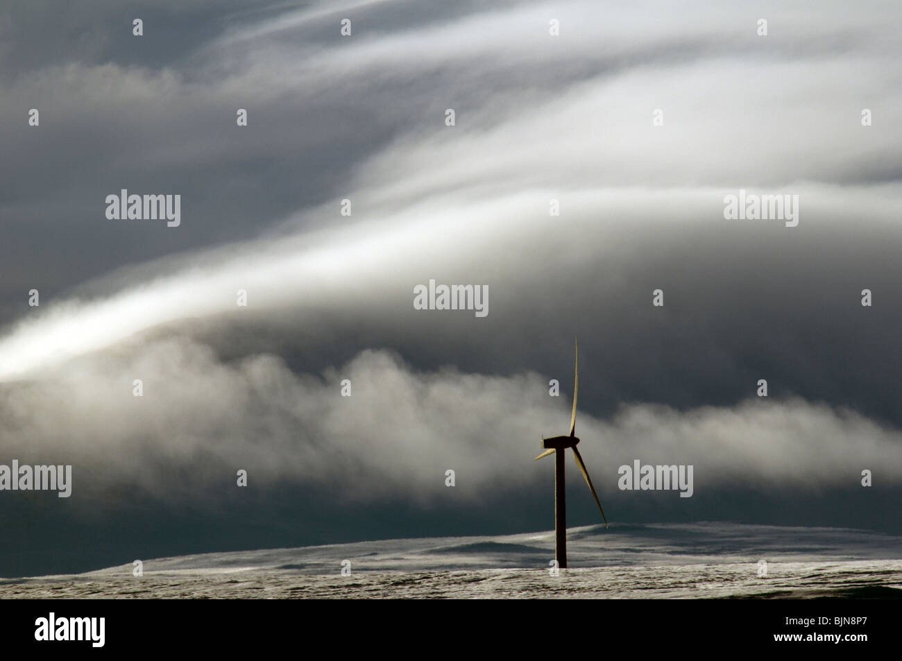 Windgenerator auf dem Schnee bedeckt Hügel in Caithness, Schottland, Vereinigtes Königreich.  Ein Nebel bedeckt Hügel hinter. Stockfoto