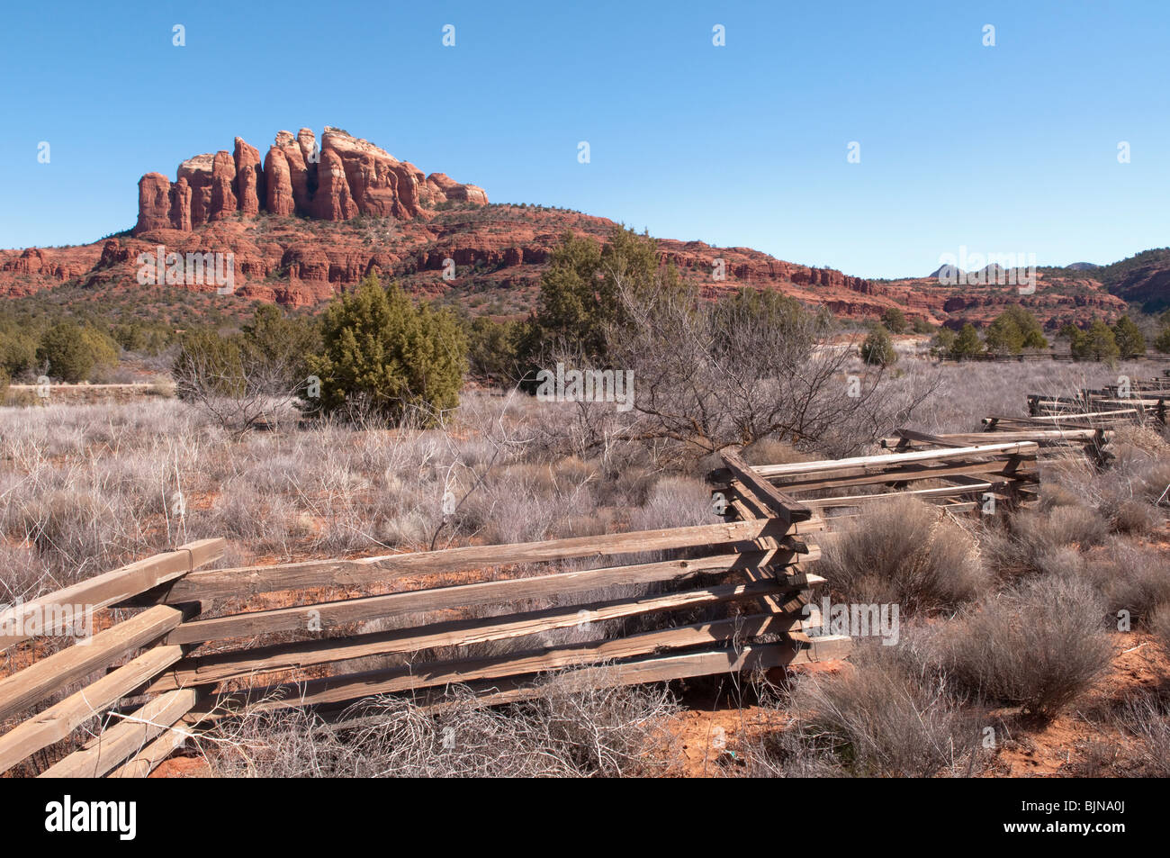 Ein Holzzaun Lager auf einer Ranch außerhalb von Sedona, Arizona. Cathedral Rocks sind in der Ferne. Stockfoto