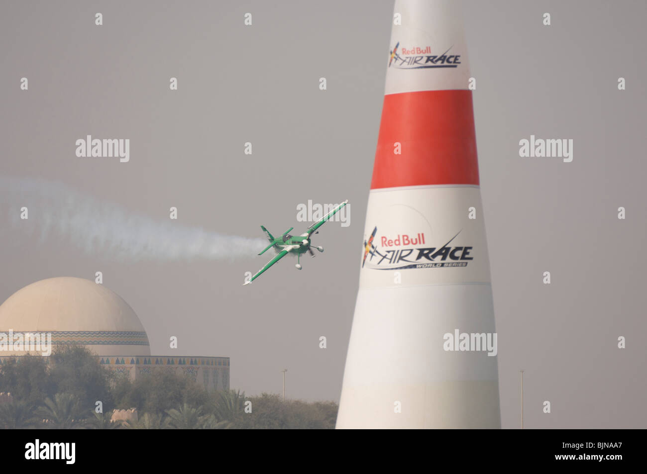 27.03.2010. Abu Dabi. Red Bull Air Race. Flugzeug fliegt zwischen Marker leuchten während des Rennens. Stockfoto