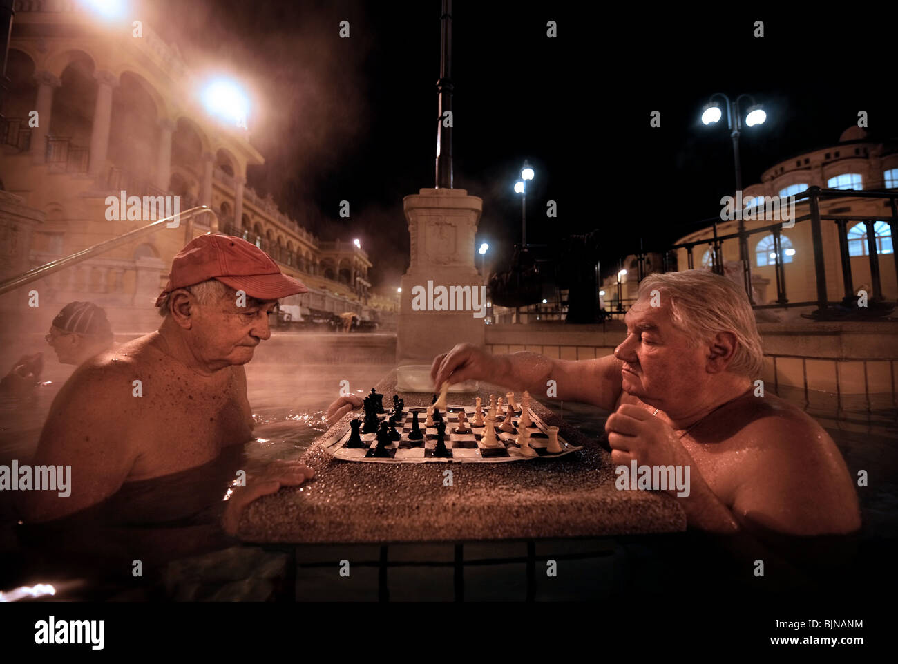 Männer spielen Schach in das Szechenyi-Bad in einer kalten Winternacht in Budapest, Ungarn Stockfoto