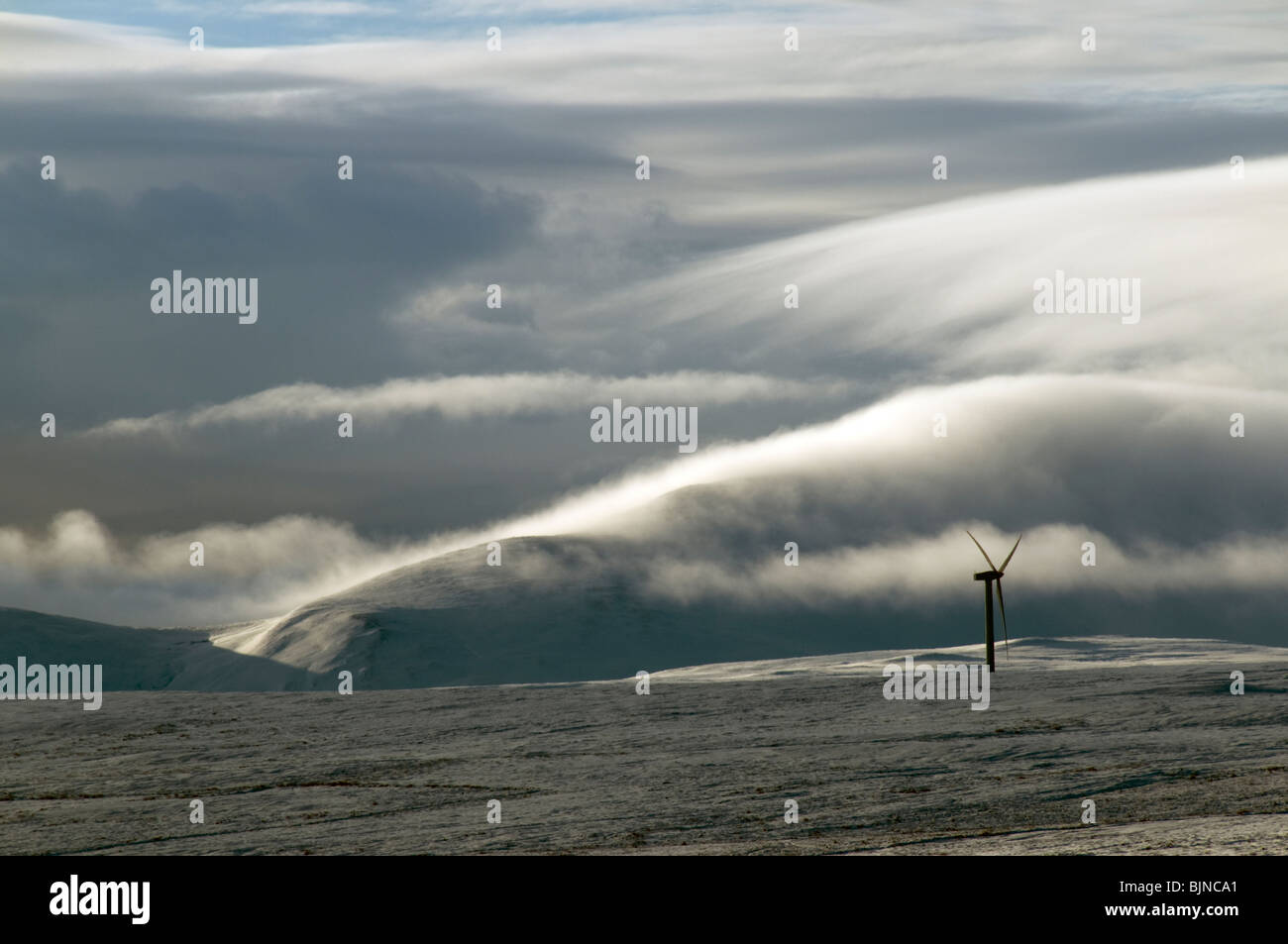 Windgeneratoren auf dem Schnee bedeckt Hügel in Caithness, Schottland, Vereinigtes Königreich.  Ein Nebel bedeckt Hügel hinter. Stockfoto