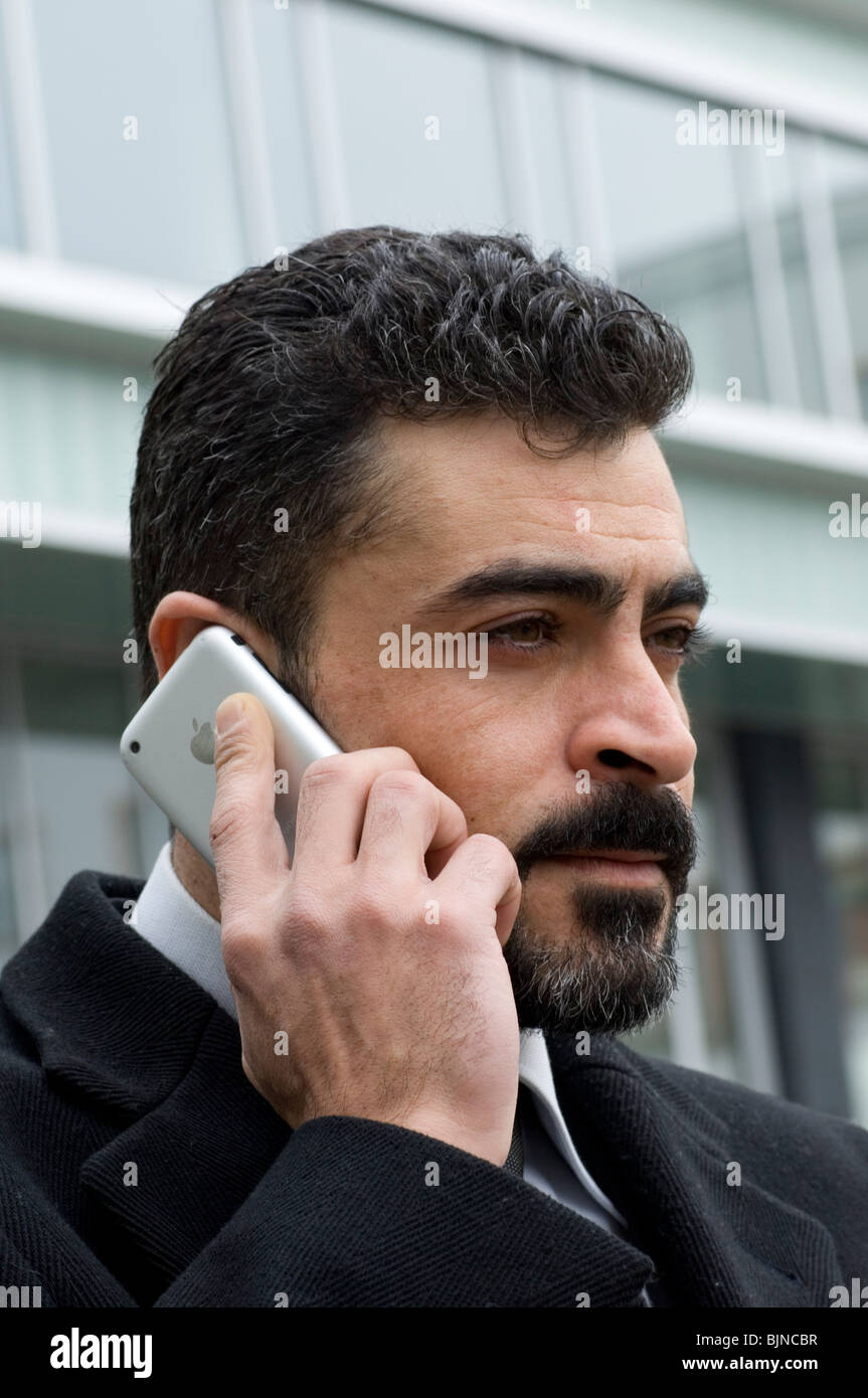 Business-Mann sprechen auf einem Iphone mobile außerhalb eines Bürogebäudes Berlin Deutschland Stockfoto