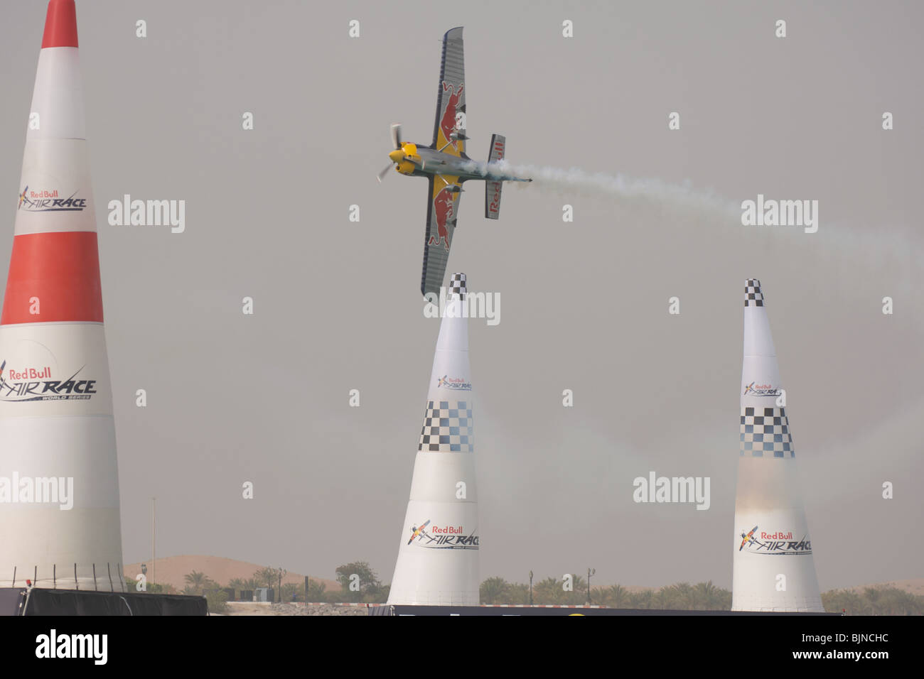 27.03.2010. Abu Dabi. Red Bull Air Race. Flugzeug fliegt zwischen Marker leuchten während des Rennens. Stockfoto