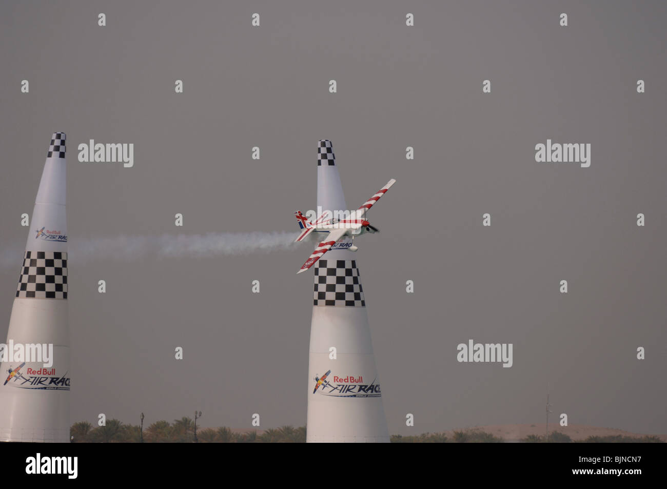 27.03.2010. Abu Dabi. Red Bull Air Race. Flugzeug fliegt zwischen Marker leuchten während des Rennens. Stockfoto