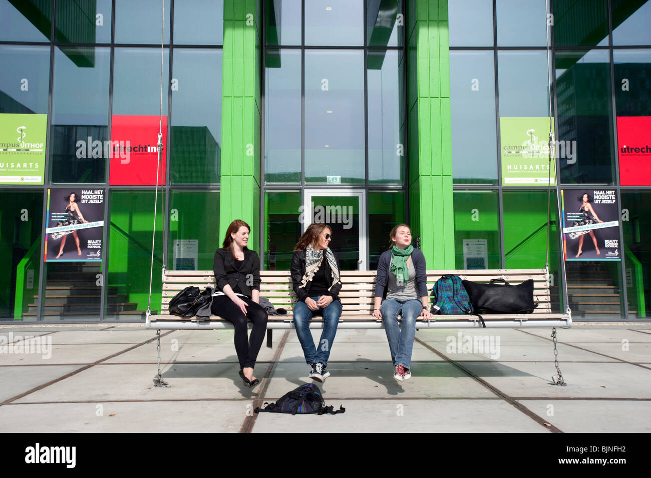 Studenten sitzen vor dem modernen Gebäude auf dem Campus der Universität Utrecht in den Niederlanden Stockfoto