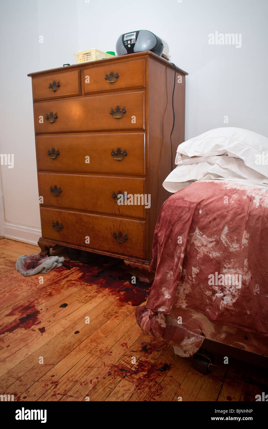 Blut befleckt Bett und Boden werden nach einem schrecklichen Unfall in einer Wohnung in New York gesehen. Stockfoto